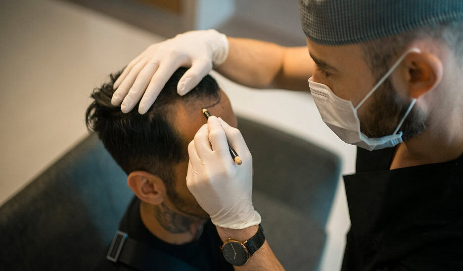 A man getting his hair transplant by a doctor